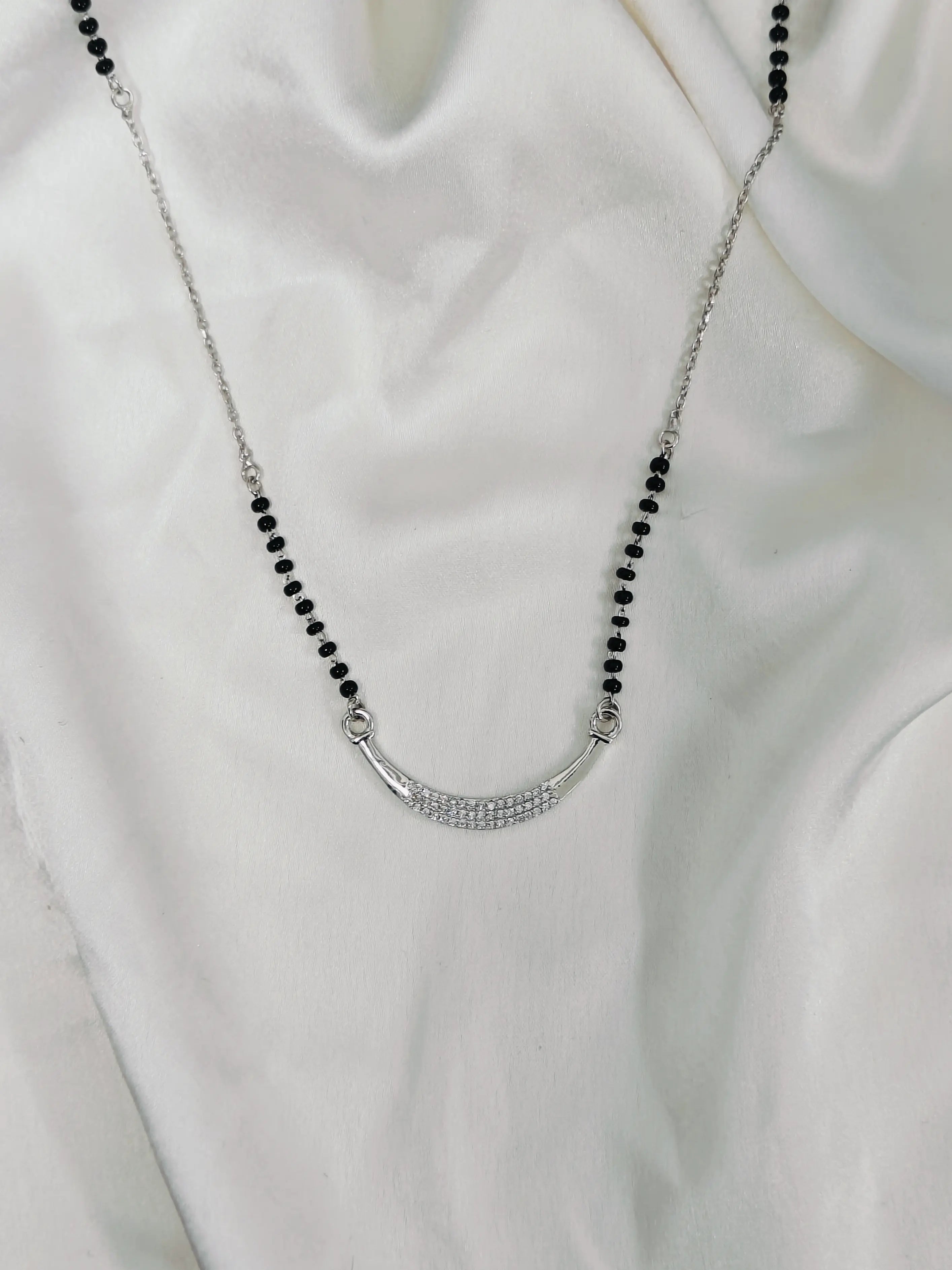 Necklace with black beads and a silver clasp on a white background
